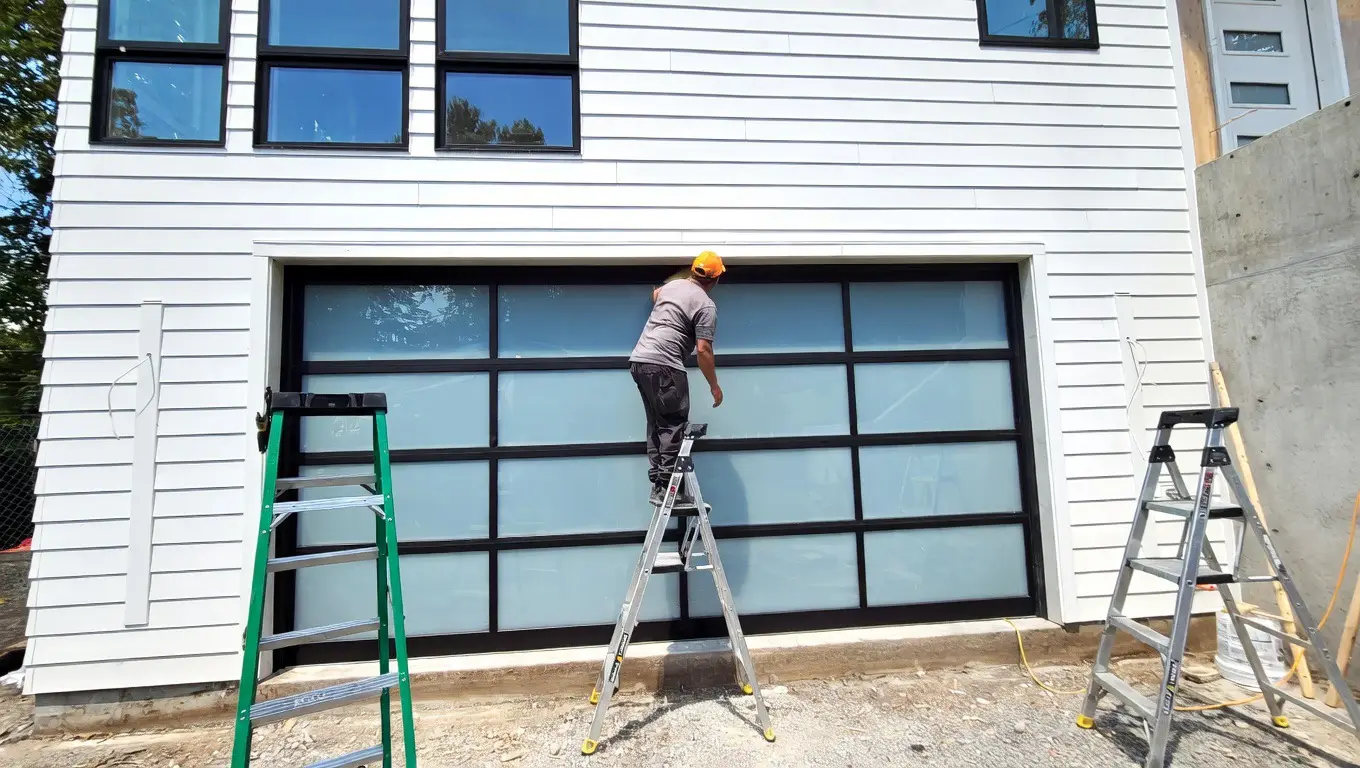 Technician installing full view glass garage door